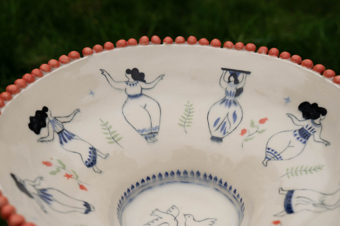 Decorative ceramic plate with hand-painted figures on a white background