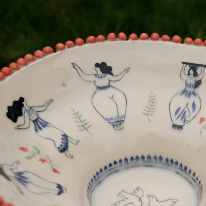 Decorative ceramic plate with hand-painted figures on a white background