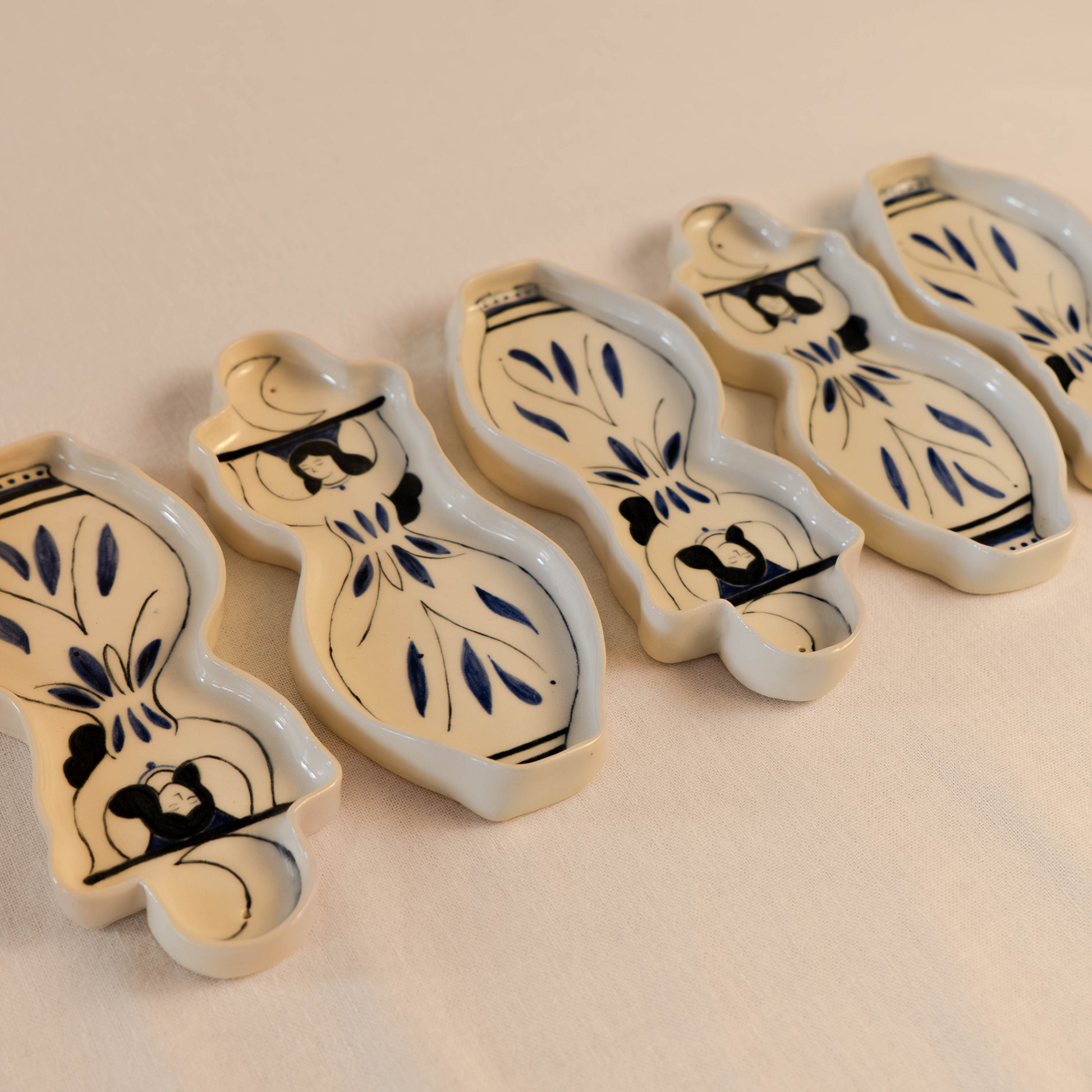 A group of five handmade ceramic incense holders shaped as moon women